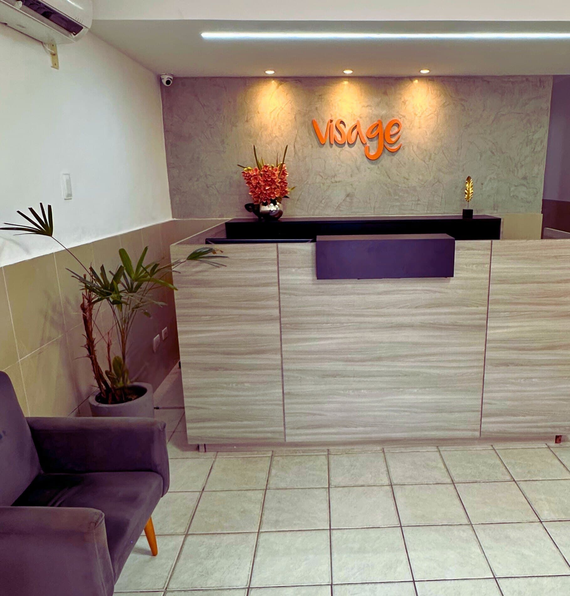 Recepção da Visage com o logotipo laranja na parede